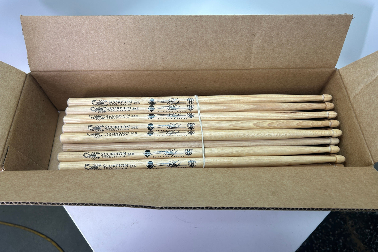 Box of Scorpion Percussion drumsticks with a brand label.