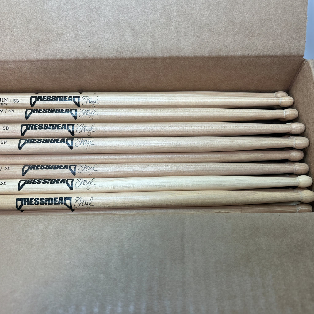 Box of drumsticks with 'Scorpion Percussion' branding on a neutral background