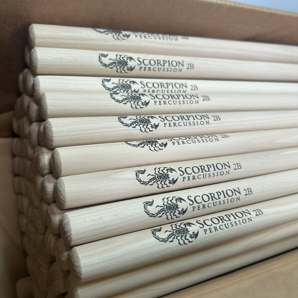 Stack of Scorpion Percussion drumsticks in a cardboard box