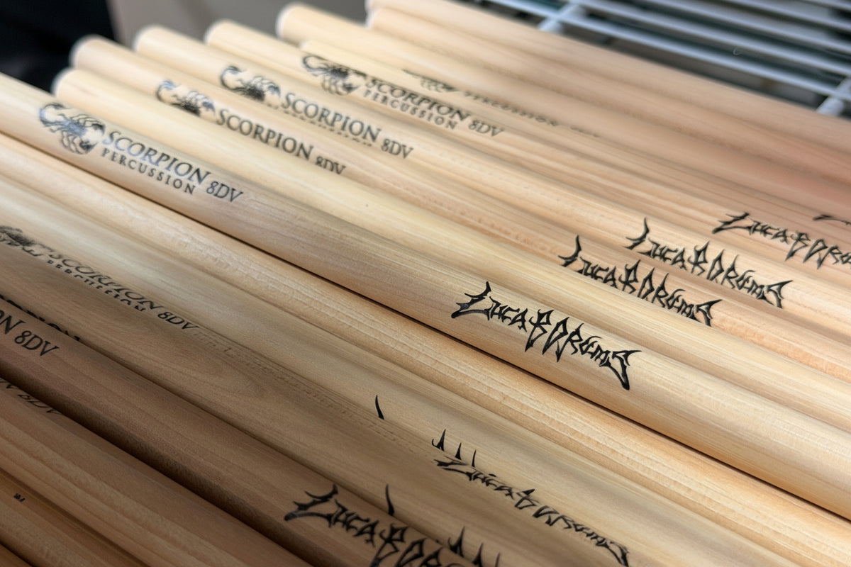 Stack of drumsticks with 'Luca B Drums Extreme' branding on a blurred background