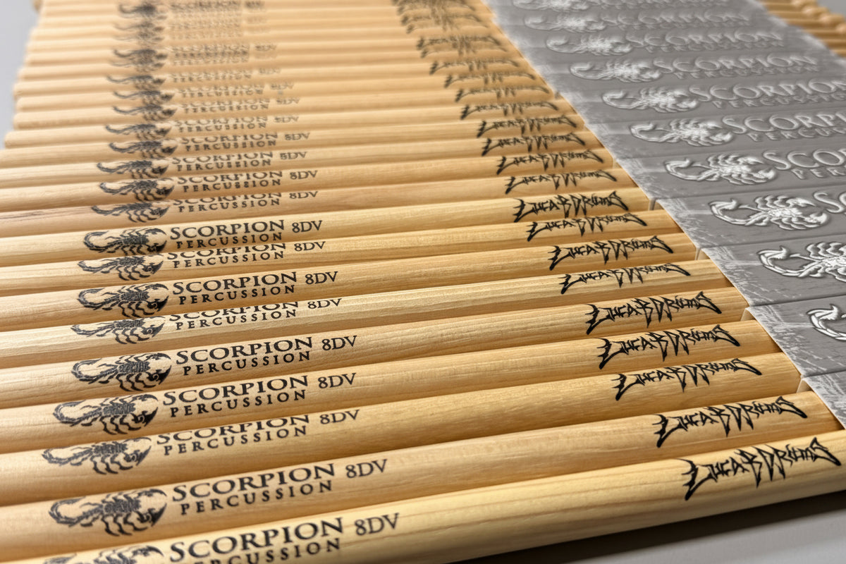 Stack of Luca B Drums Immortal Series Scorpion 8DV Percussion branding on a metallic surface.